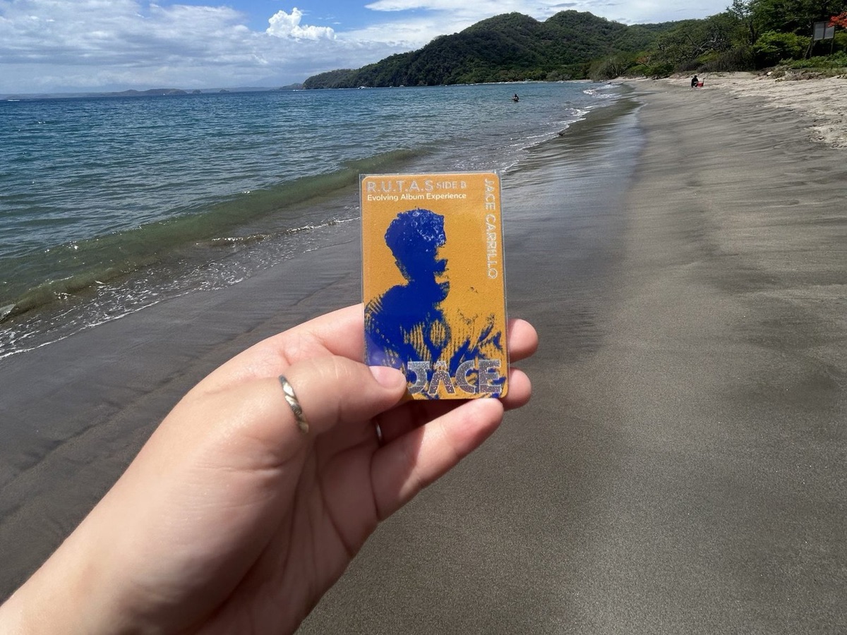 An Album.Card held up on a beach